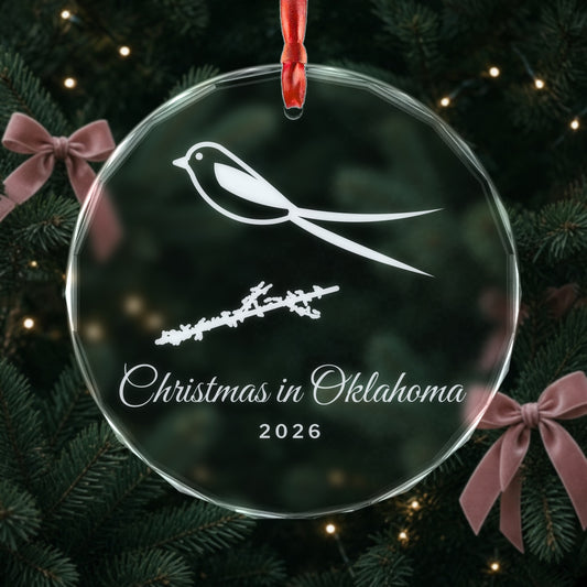 Engraved Christmas in Oklahoma 2026 crystal ornament with a scissortail flycatcher hanging on a Christmas tree with pink bows