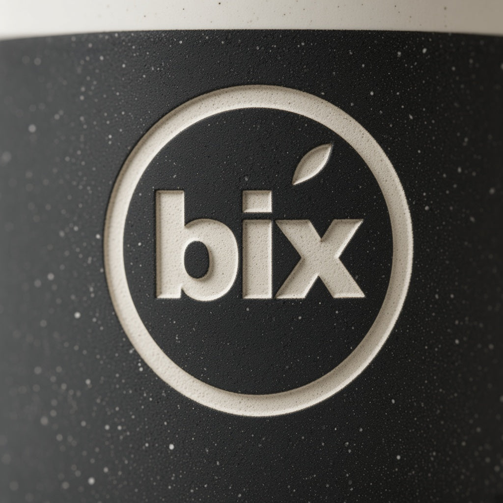 Close-up of lowercase bix badge engraved through black speckled glaze