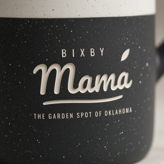 Close-up of Bixby Mama script engraved through black speckled glaze
